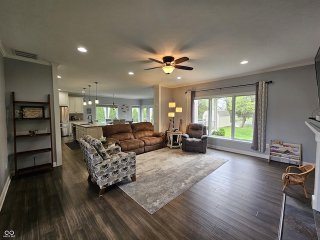 living area with crown molding, recessed lighting, ceiling fan, and dark wood-style flooring