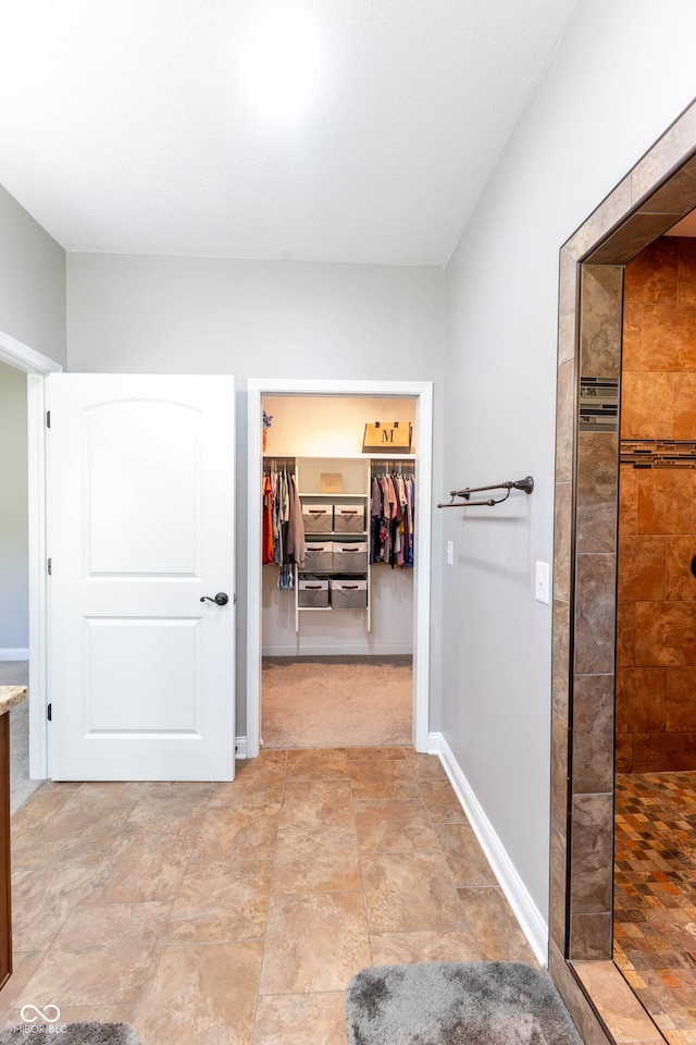 hallway featuring baseboards and stone finish floor