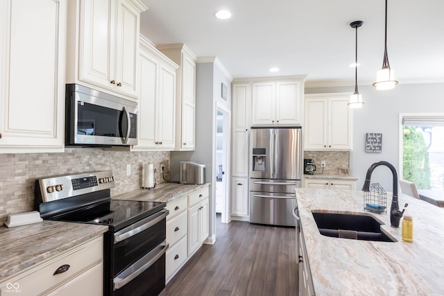 kitchen with light stone countertops, dark wood-type flooring, tasteful backsplash, a sink, and stainless steel appliances