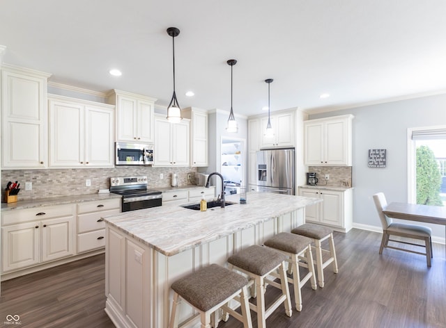 kitchen with decorative backsplash, a breakfast bar area, a sink, dark wood finished floors, and stainless steel appliances