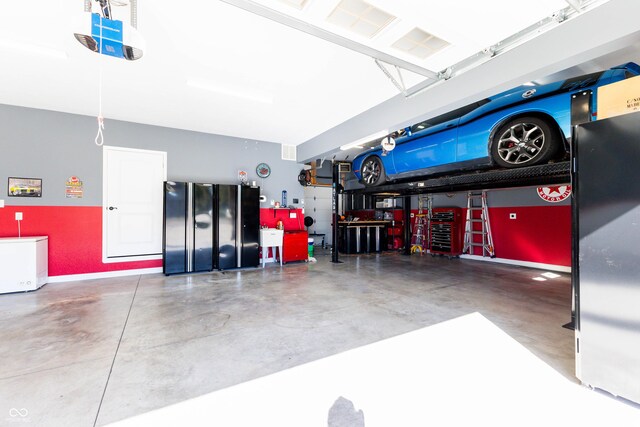 garage with freestanding refrigerator and baseboards