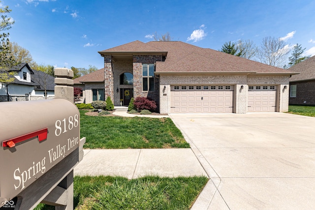 view of front facade featuring driveway, brick siding, a front lawn, an attached garage, and a shingled roof