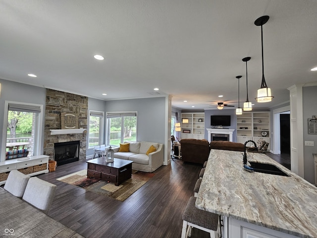 living room with recessed lighting, dark wood finished floors, ceiling fan, and a fireplace