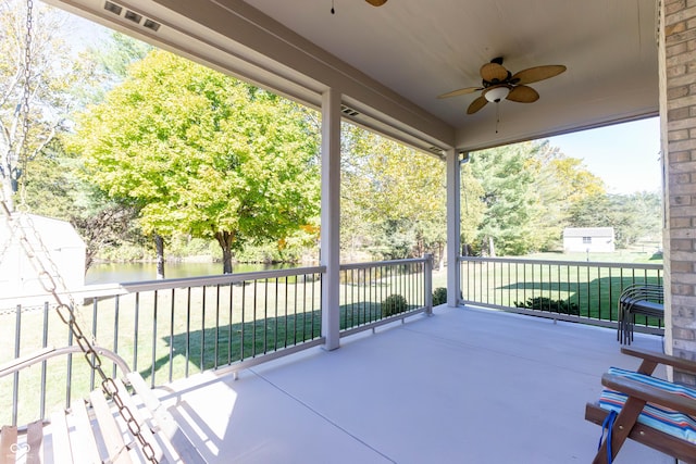 view of patio with a water view and ceiling fan