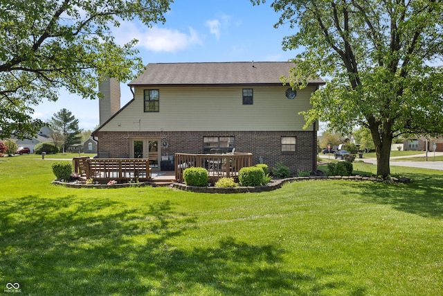 back of house featuring brick siding, french doors, a deck, a chimney, and a lawn