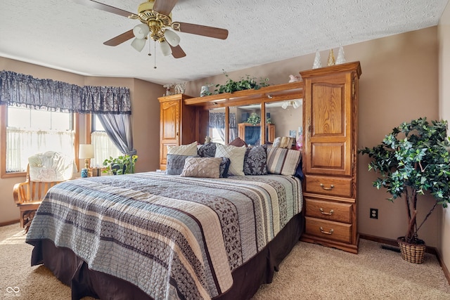 bedroom with baseboards, a textured ceiling, ceiling fan, and light carpet