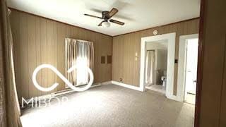 carpeted spare room featuring baseboards and ceiling fan