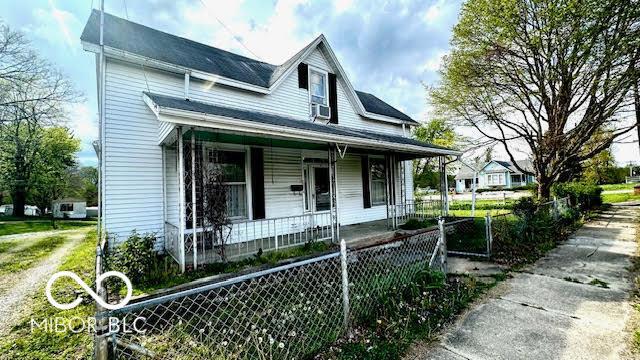 view of front facade with a porch and fence private yard