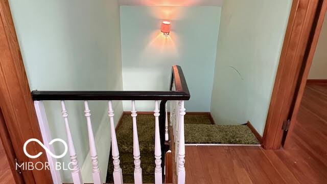 stairway with baseboards and wood finished floors