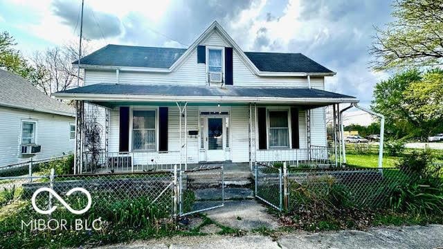 bungalow-style house featuring a gate, a fenced front yard, and a porch