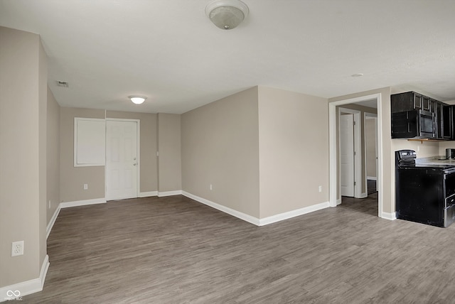 interior space with baseboards, visible vents, and wood finished floors