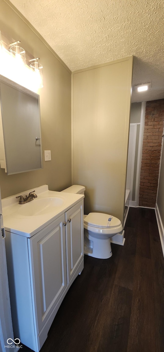 bathroom with vanity, a textured ceiling, toilet, and wood finished floors