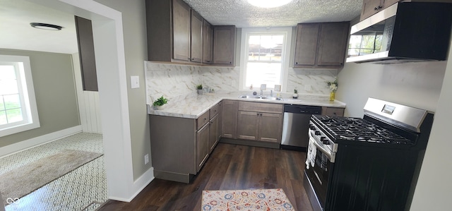 kitchen with light countertops, stainless steel appliances, decorative backsplash, and plenty of natural light