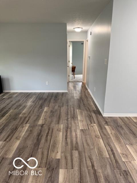 unfurnished room with baseboards and wood finished floors