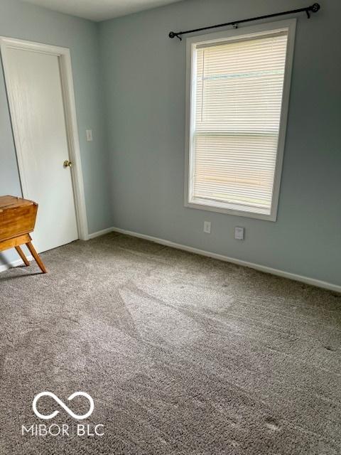 empty room featuring baseboards and carpet