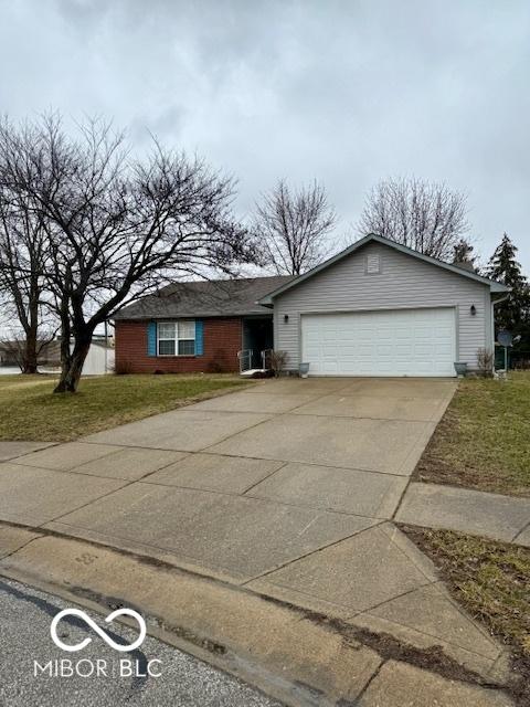 single story home with an attached garage, concrete driveway, and a front yard