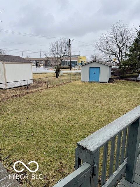 view of yard with a storage unit, an outdoor structure, and fence