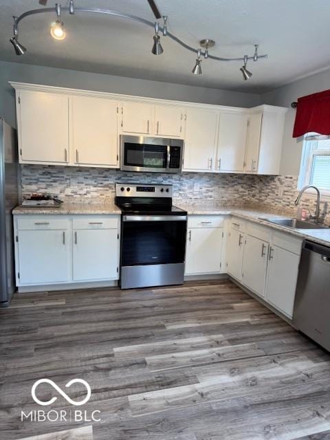 kitchen with a sink, appliances with stainless steel finishes, white cabinets, and light countertops