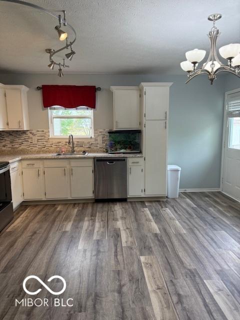kitchen featuring a sink, light countertops, stainless steel dishwasher, and a healthy amount of sunlight