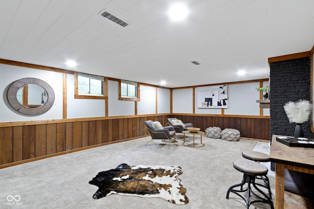 interior space with wooden walls, visible vents, wainscoting, and carpet