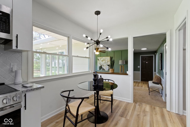 dining area featuring light wood finished floors, an inviting chandelier, and a wealth of natural light