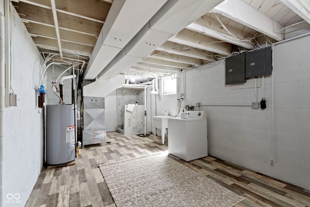 below grade area with gas water heater, electric panel, wood finished floors, and washer / clothes dryer