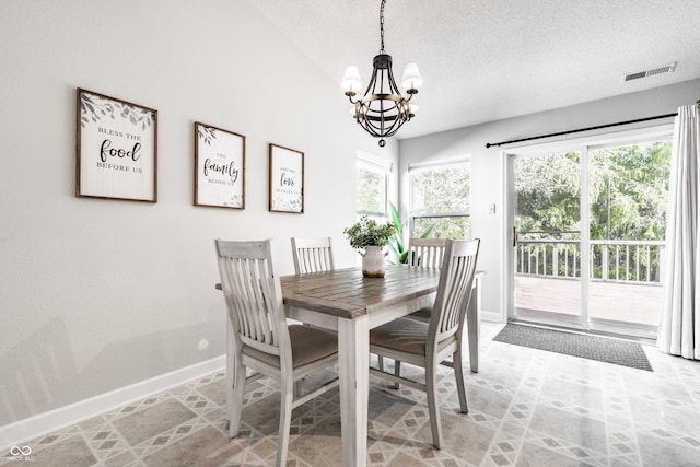 dining room with visible vents, baseboards, a textured ceiling, a notable chandelier, and vaulted ceiling