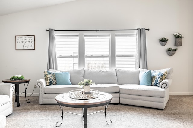 living area with baseboards, light carpet, and lofted ceiling