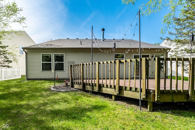 back of house with a lawn, fence, and a deck