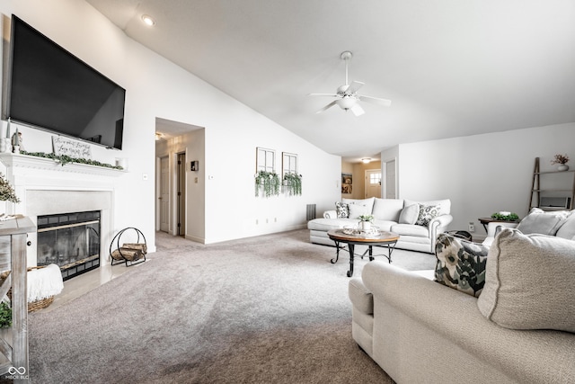 living room with ceiling fan, a fireplace with flush hearth, carpet, and high vaulted ceiling