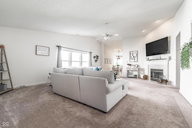 carpeted living area with baseboards, a ceiling fan, a fireplace with flush hearth, and lofted ceiling