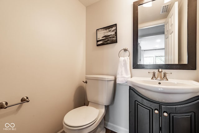 bathroom with baseboards, toilet, and vanity
