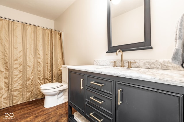 full bathroom featuring wood finished floors, toilet, vanity, and curtained shower