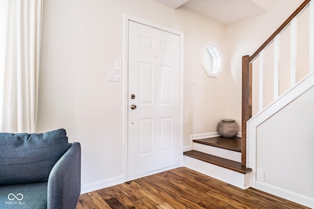 entryway with stairway, dark wood-style flooring, and baseboards