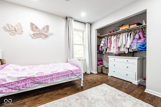 bedroom featuring a closet, dark wood finished floors, and baseboards