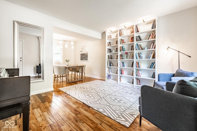 sitting room featuring wood finished floors, a chandelier, and baseboards