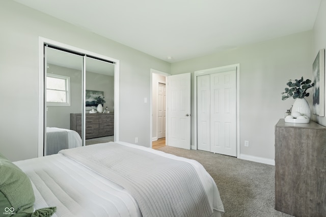 bedroom featuring multiple closets, baseboards, and carpet floors