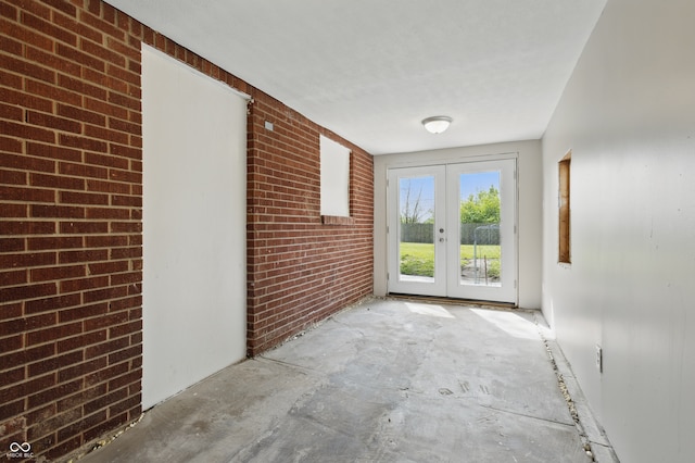 interior space featuring french doors and brick wall