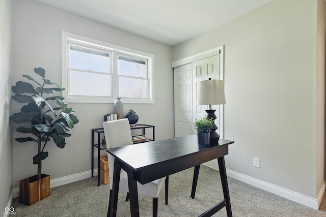 home office with baseboards and light carpet