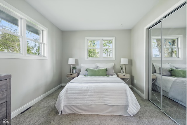 carpeted bedroom with a closet and baseboards