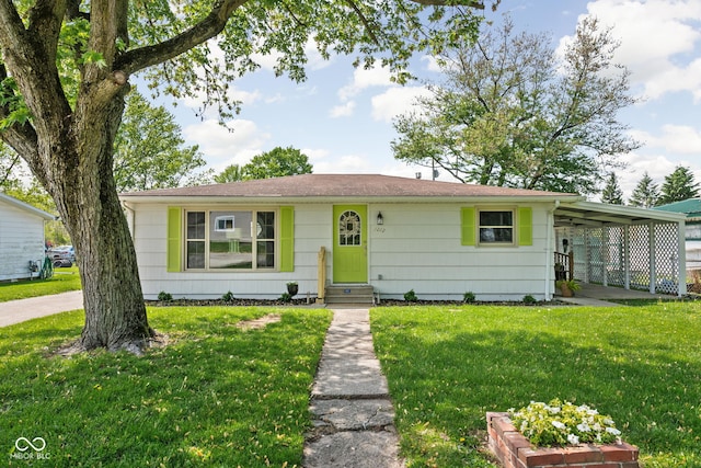 view of front of home featuring entry steps, a front yard, and an attached carport
