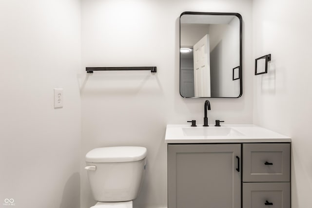 half bath featuring vanity and toilet