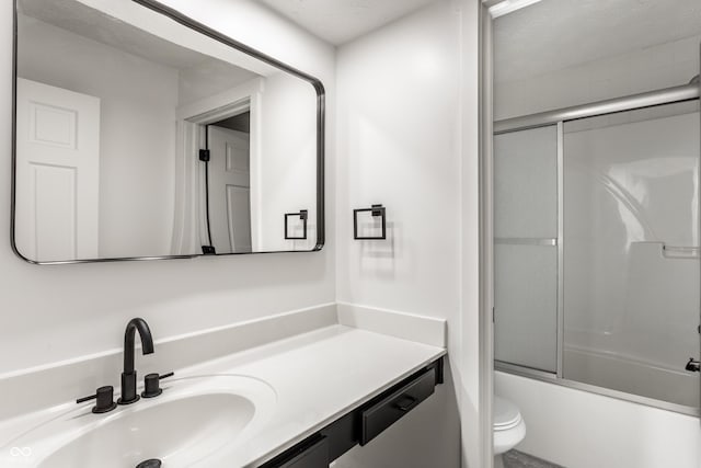 bathroom with vanity, bath / shower combo with glass door, and toilet