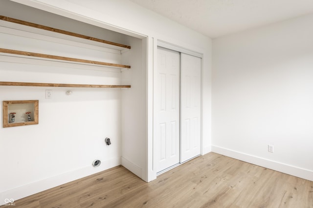 laundry room featuring laundry area, baseboards, and light wood finished floors