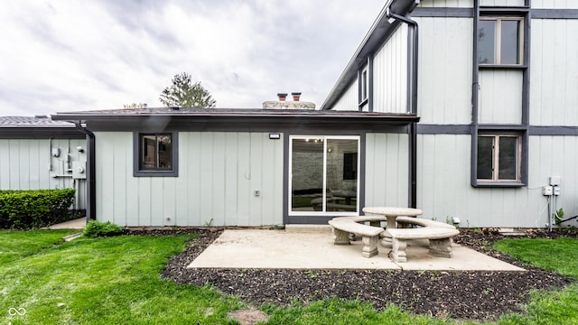 rear view of property with a lawn and a patio area