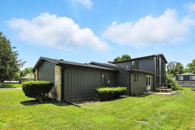 660 Sun Valley Ct, Indianapolis, IN 46217 - back of property featuring a yard, a patio area, stone siding, and board and batten siding