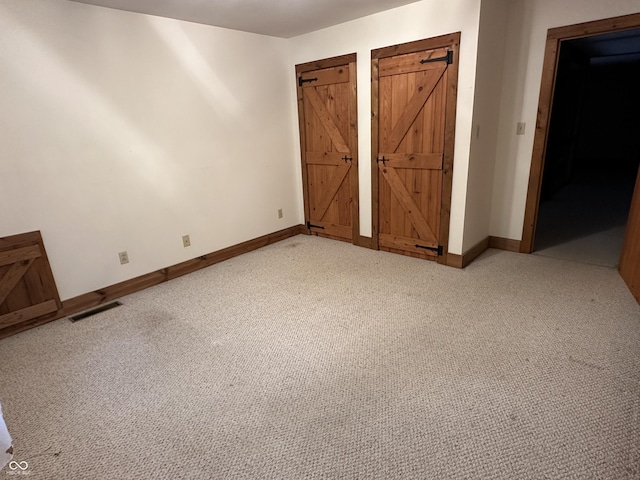 10770 W 650 S, Columbus, IN 47201 - unfurnished bedroom with baseboards, light colored carpet, a barn door, and visible vents