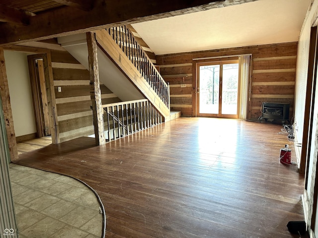 10770 W 650 S, Columbus, IN 47201 - unfurnished living room featuring wooden walls, stairway, a wood stove, and hardwood / wood-style floors