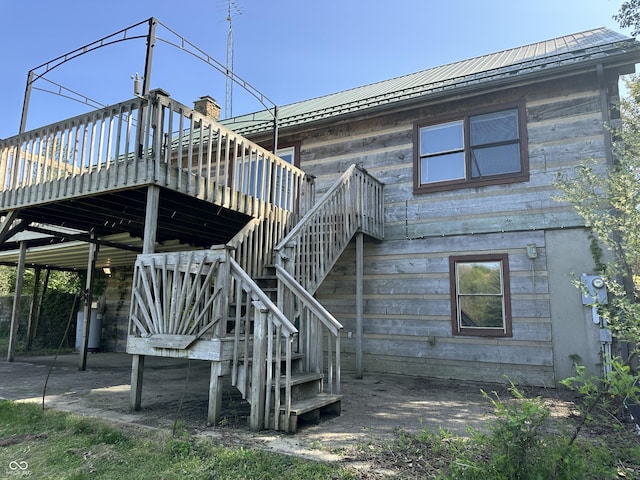 10770 W 650 S, Columbus, IN 47201 - rear view of house with stairway, a wooden deck, water heater, and metal roof