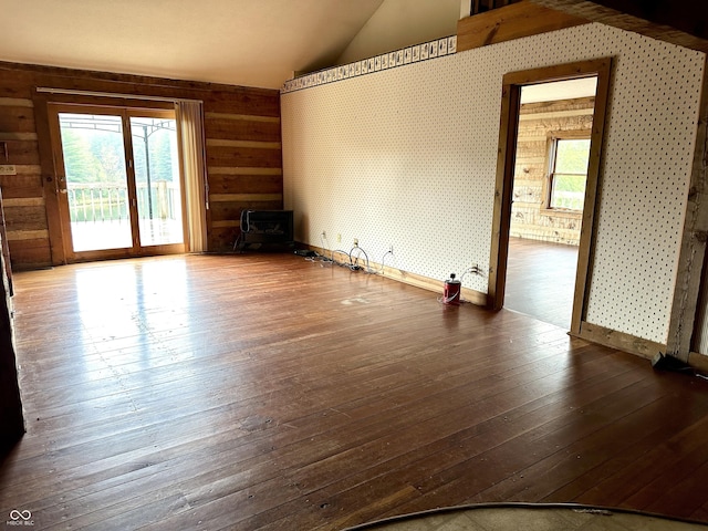 10770 W 650 S, Columbus, IN 47201 - spare room featuring a wood stove, wood walls, vaulted ceiling, and hardwood / wood-style flooring